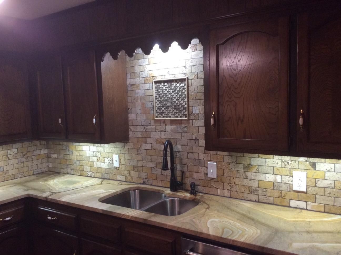 A kitchen with two sinks and wooden cabinets