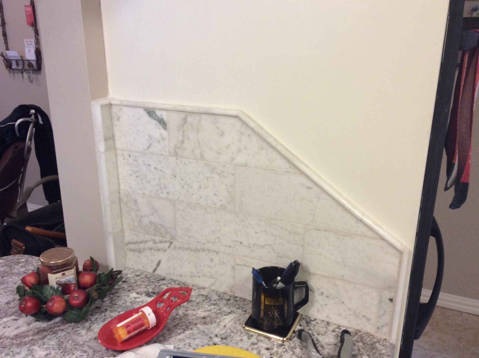 A kitchen counter with a coffee maker and a pill bottle on it