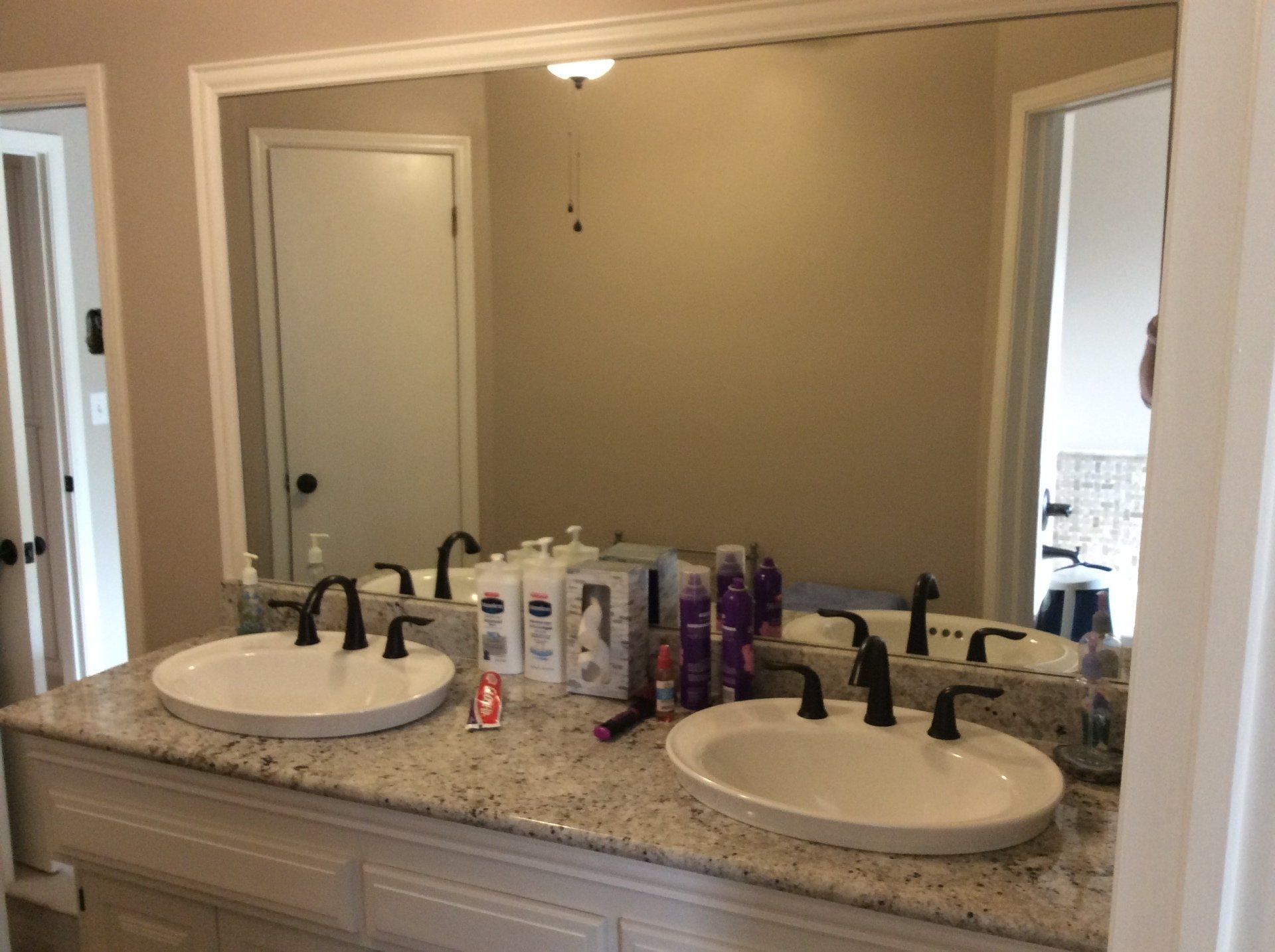 A bathroom with two sinks and a large mirror.