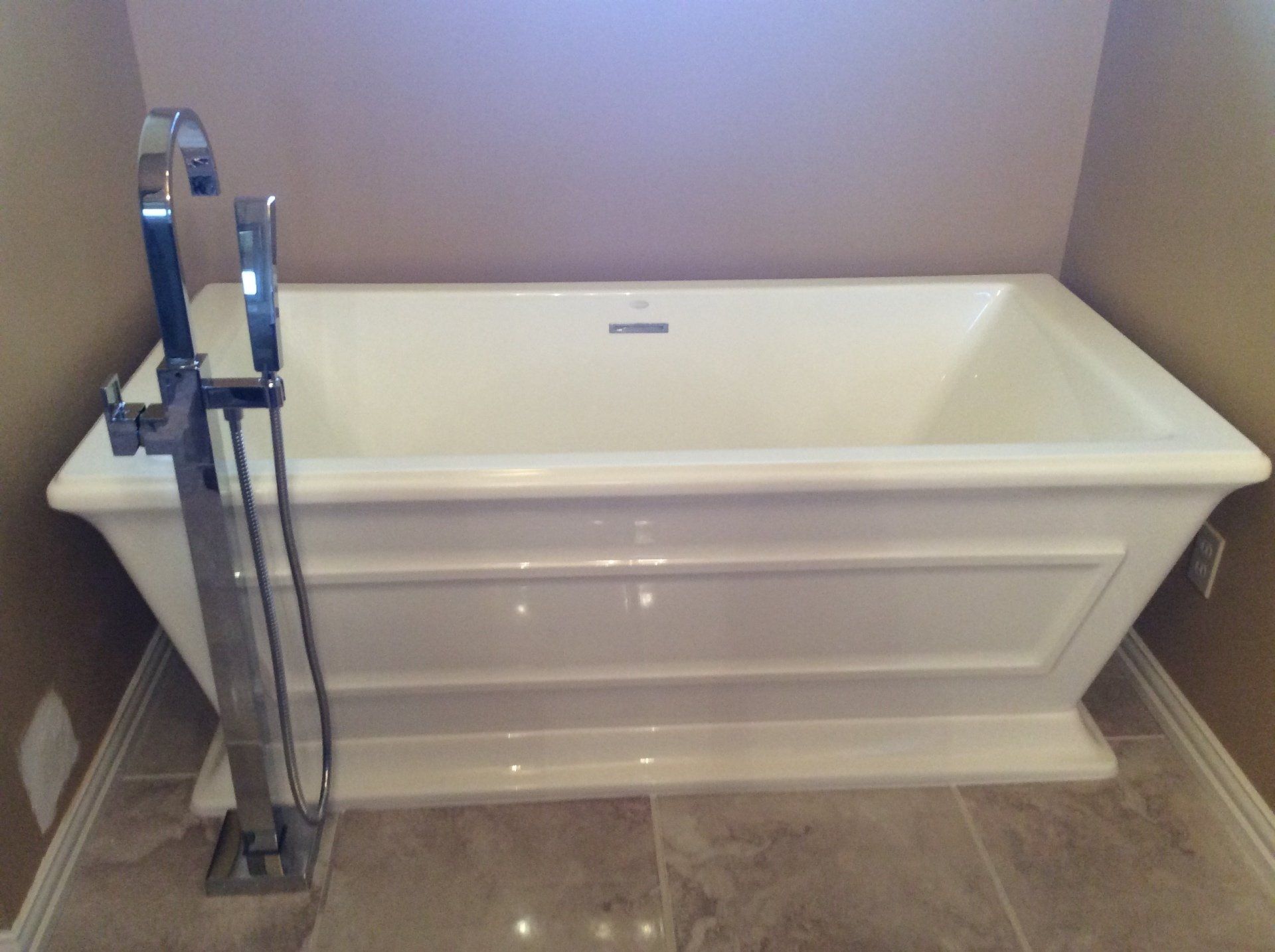 A white bathtub with a chrome faucet in a bathroom