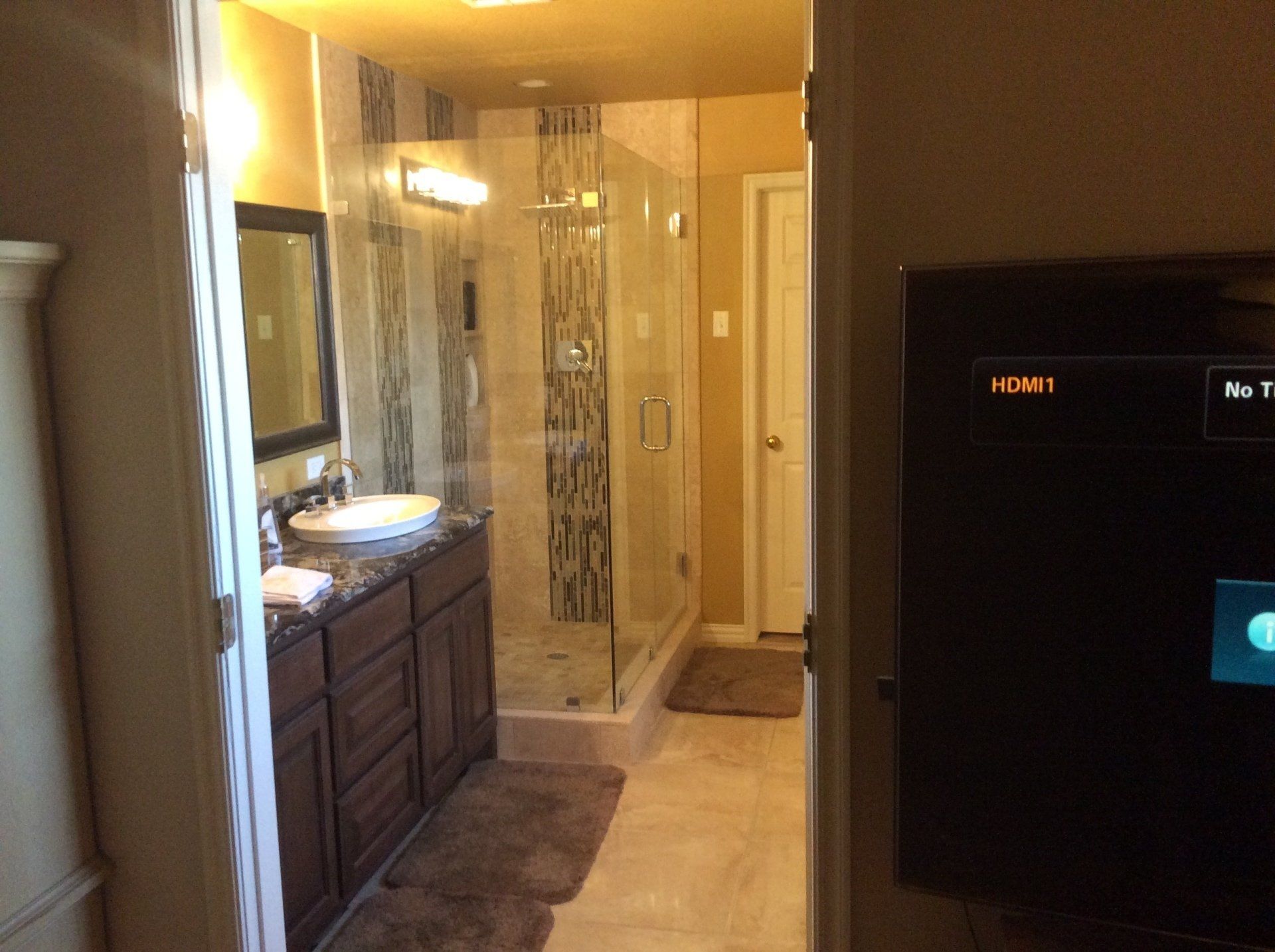 A bathroom with a sink , mirror , and shower.
