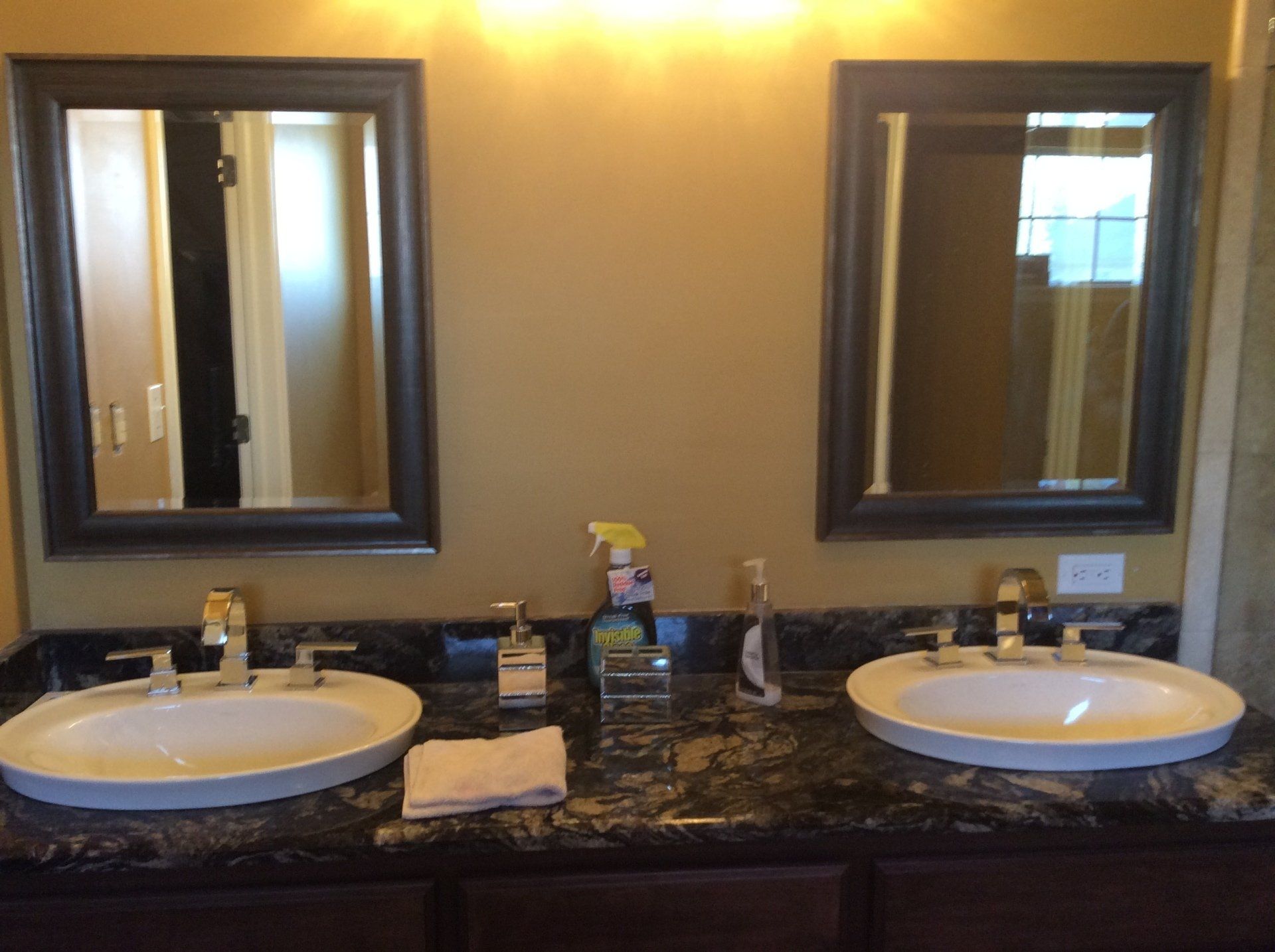 A bathroom with two sinks and two mirrors