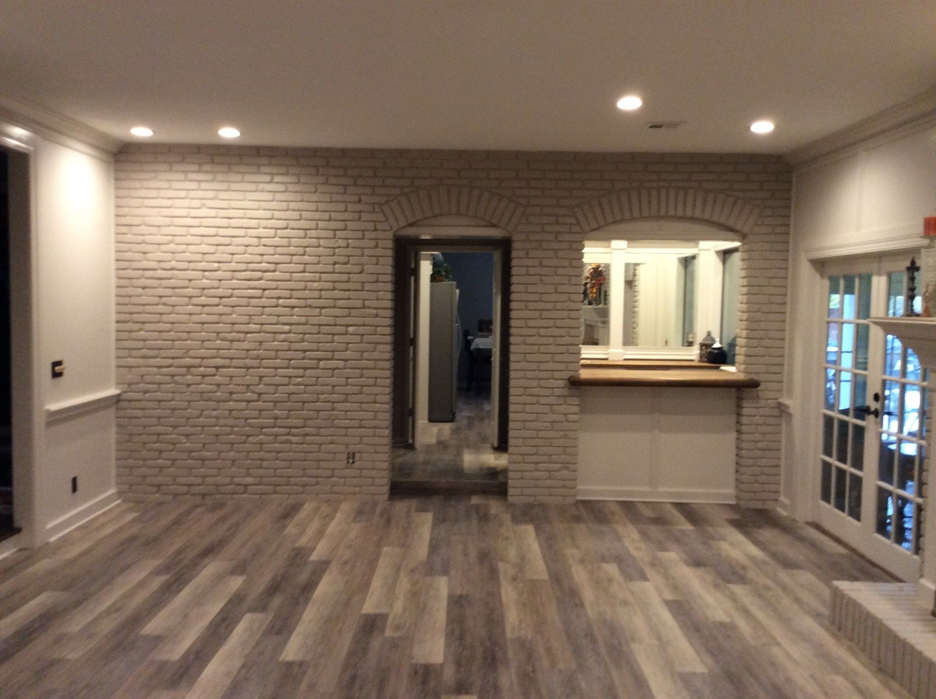 A living room with a brick wall and a wooden floor.