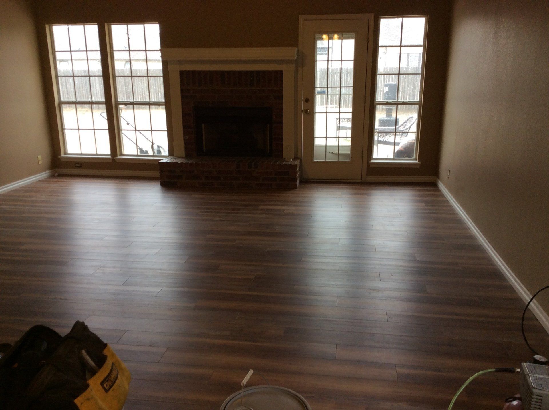 An empty living room with hardwood floors and a fireplace