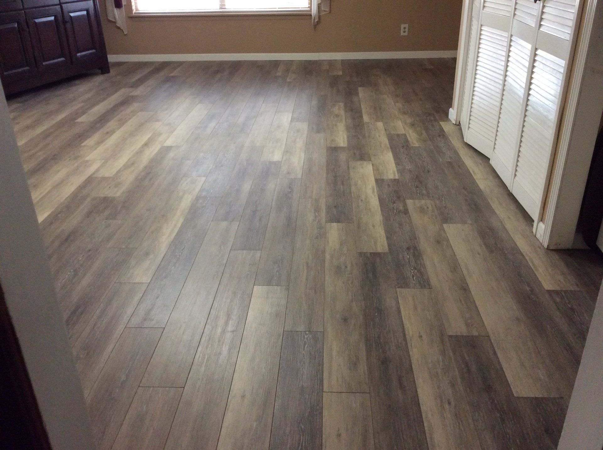 A living room with a wooden floor and a window.