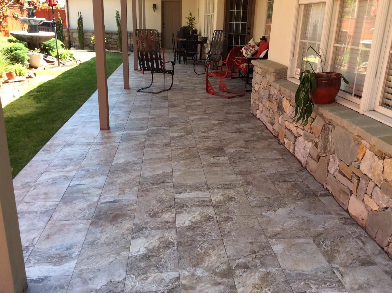 A patio with rocking chairs and a table on it