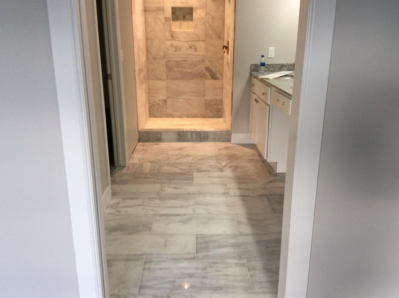 A bathroom with a walk in shower and a sink.