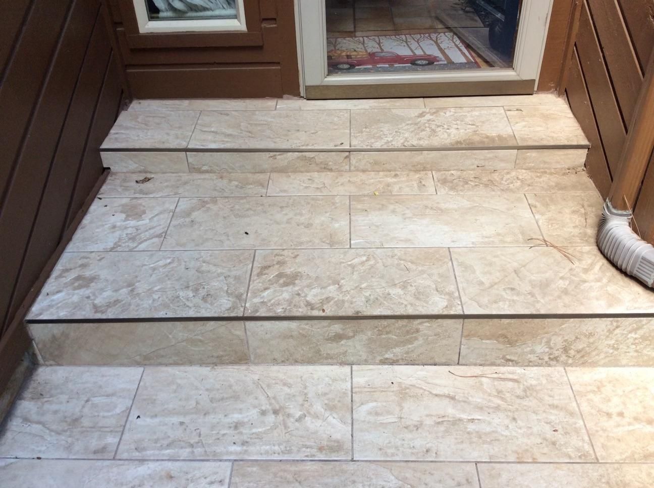 A set of tiled steps leading up to a door.