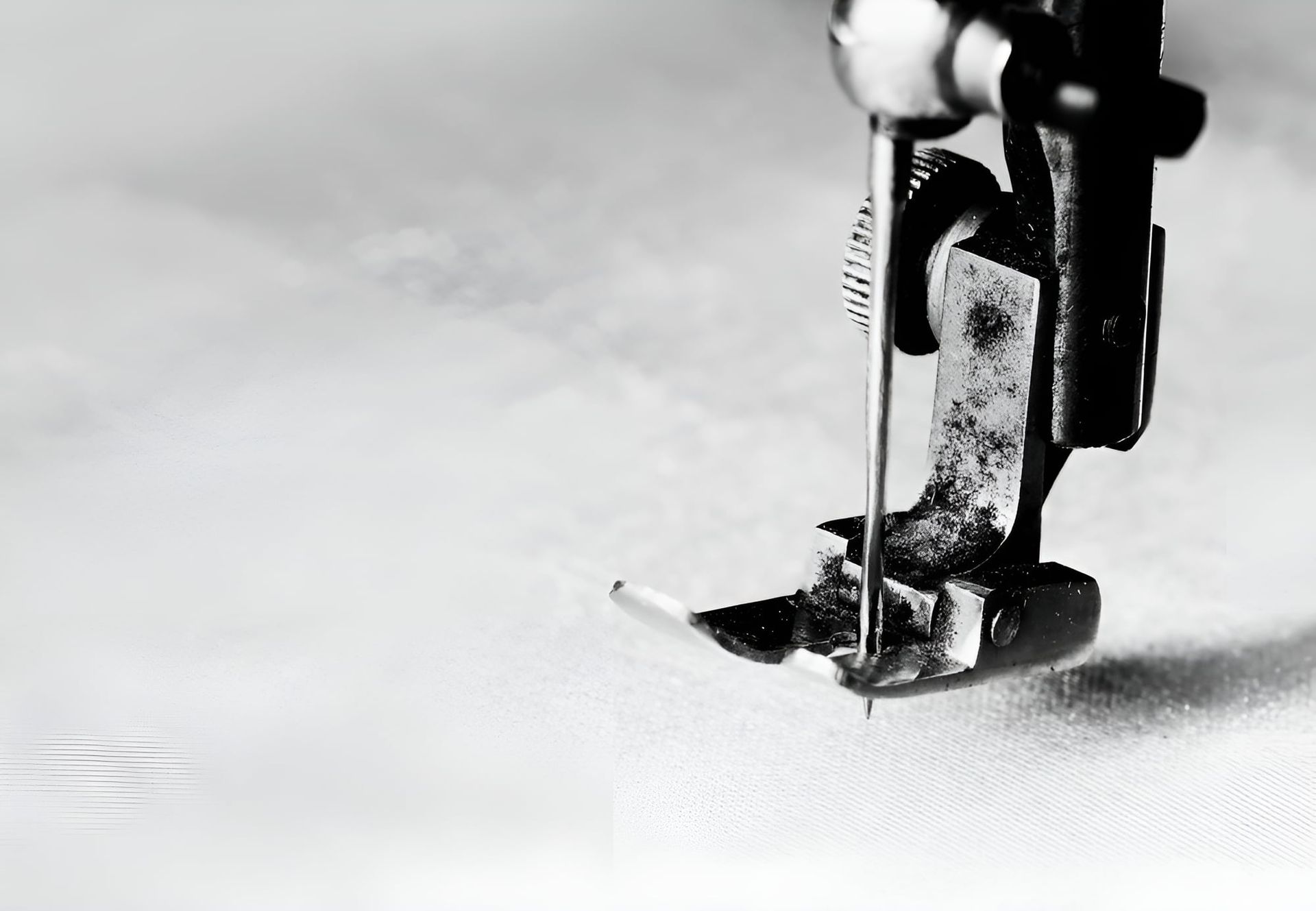 A Black And White Photo Of A Sewing Machine Cutting A Piece Of Fabric — Gympie Embroidery Services In Southside, QLD