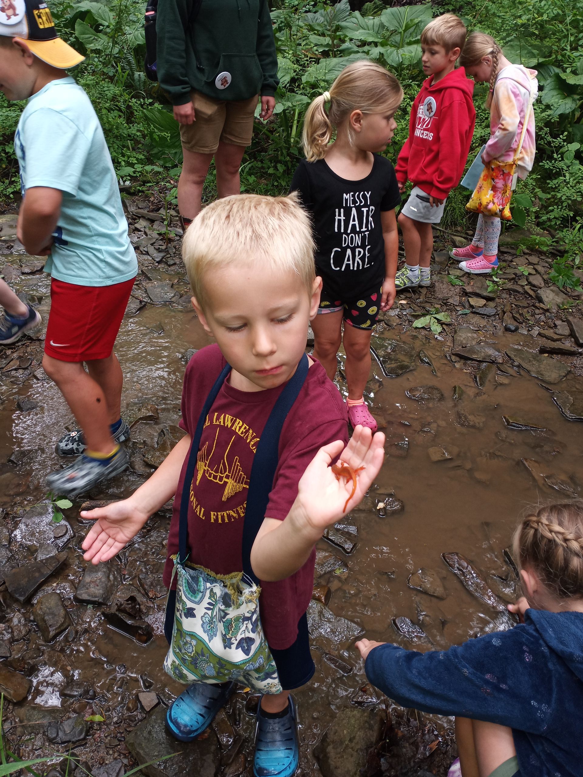 A group of children are playing in a muddy puddle.