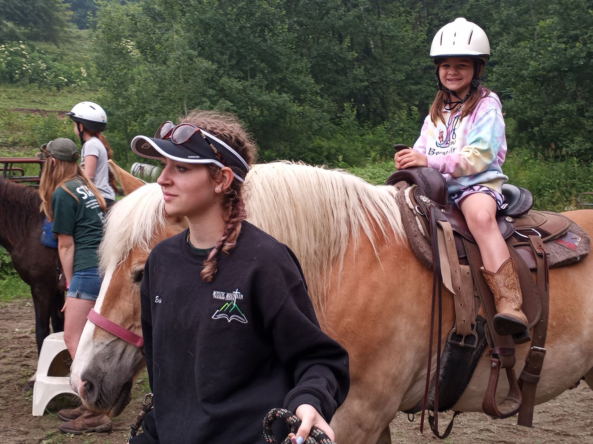 A girl is riding on the back of a brown horse