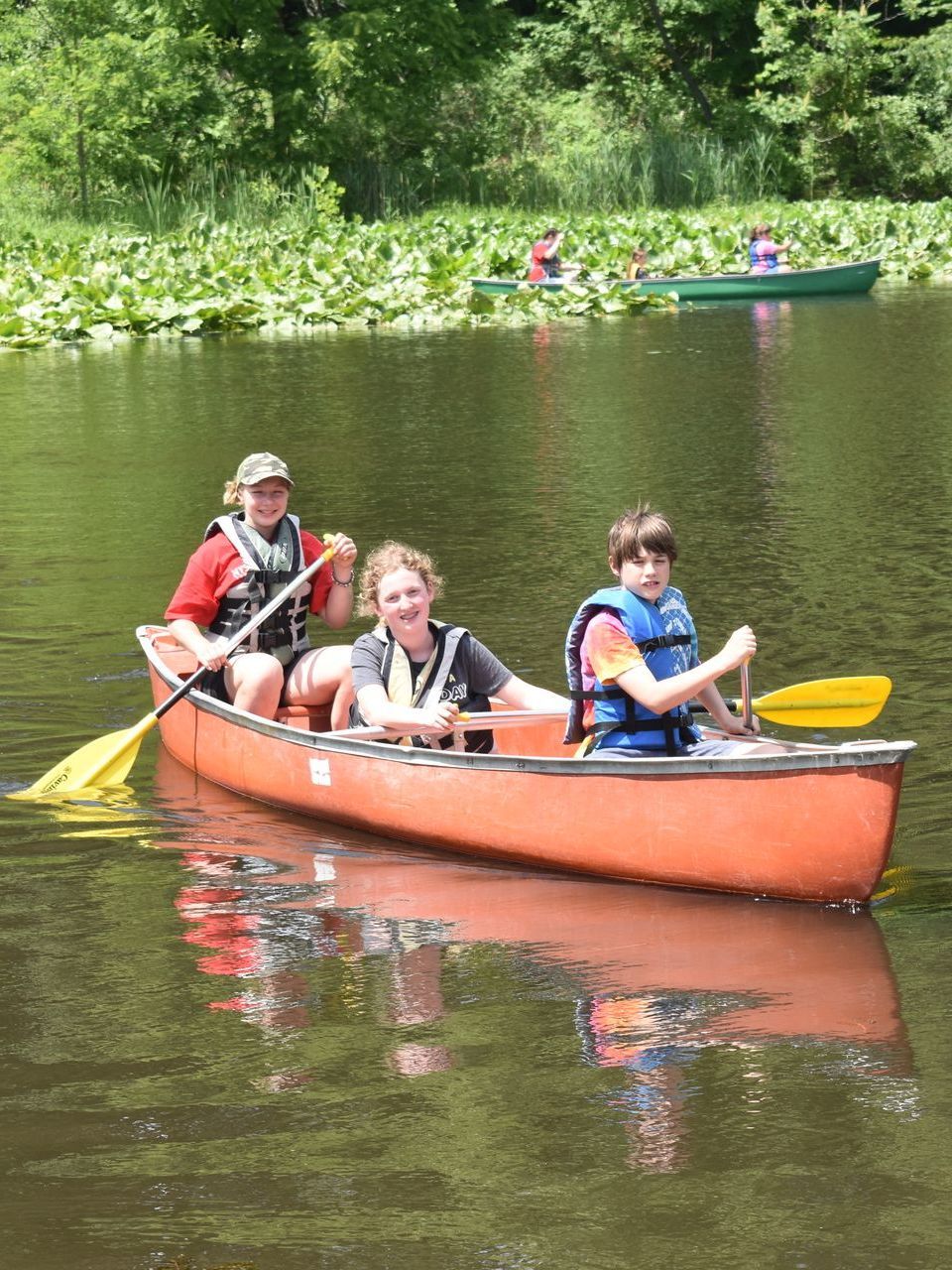 A group of people are in a canoe on a lake.