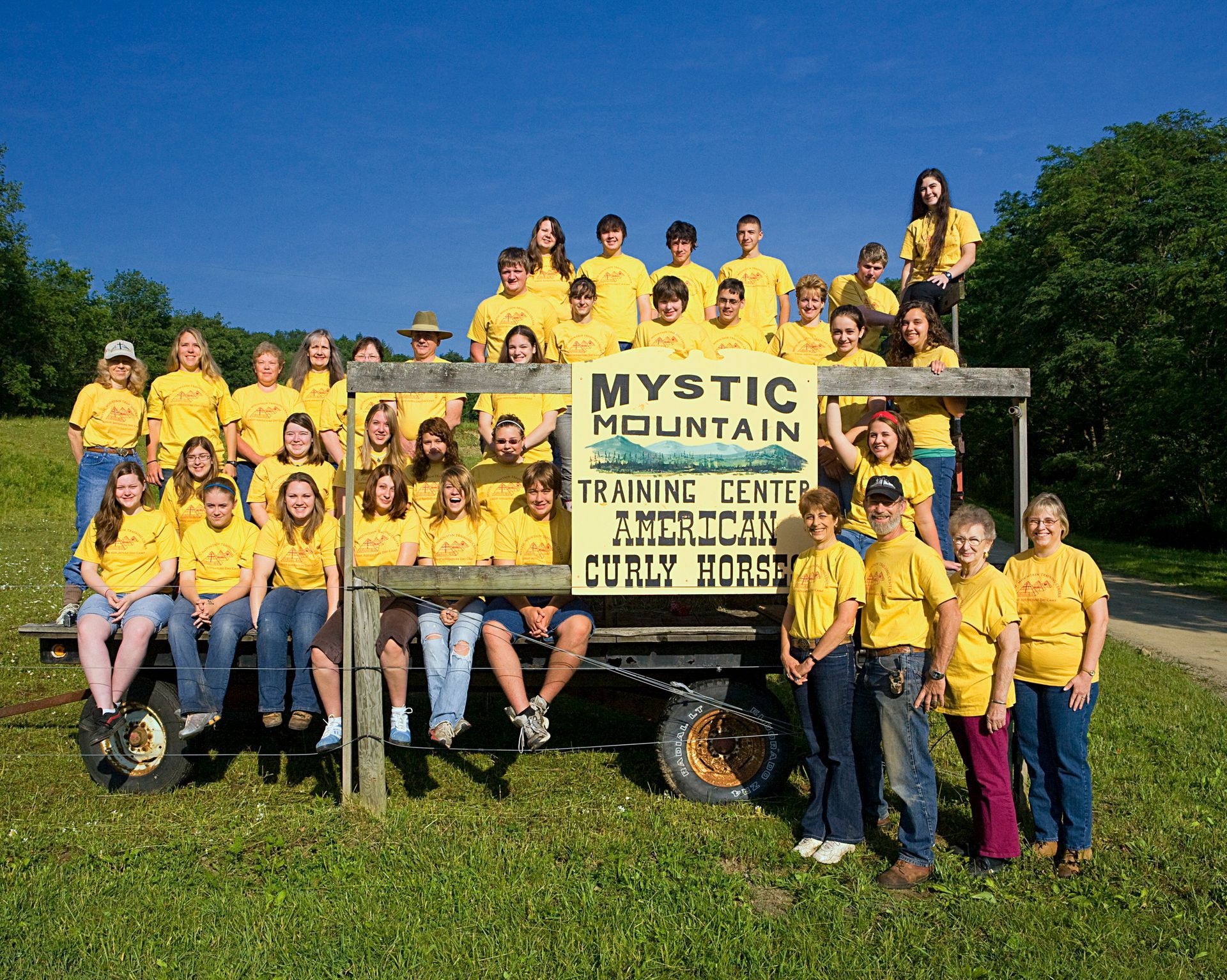 A group of people standing in front of a sign that says mystic mountain