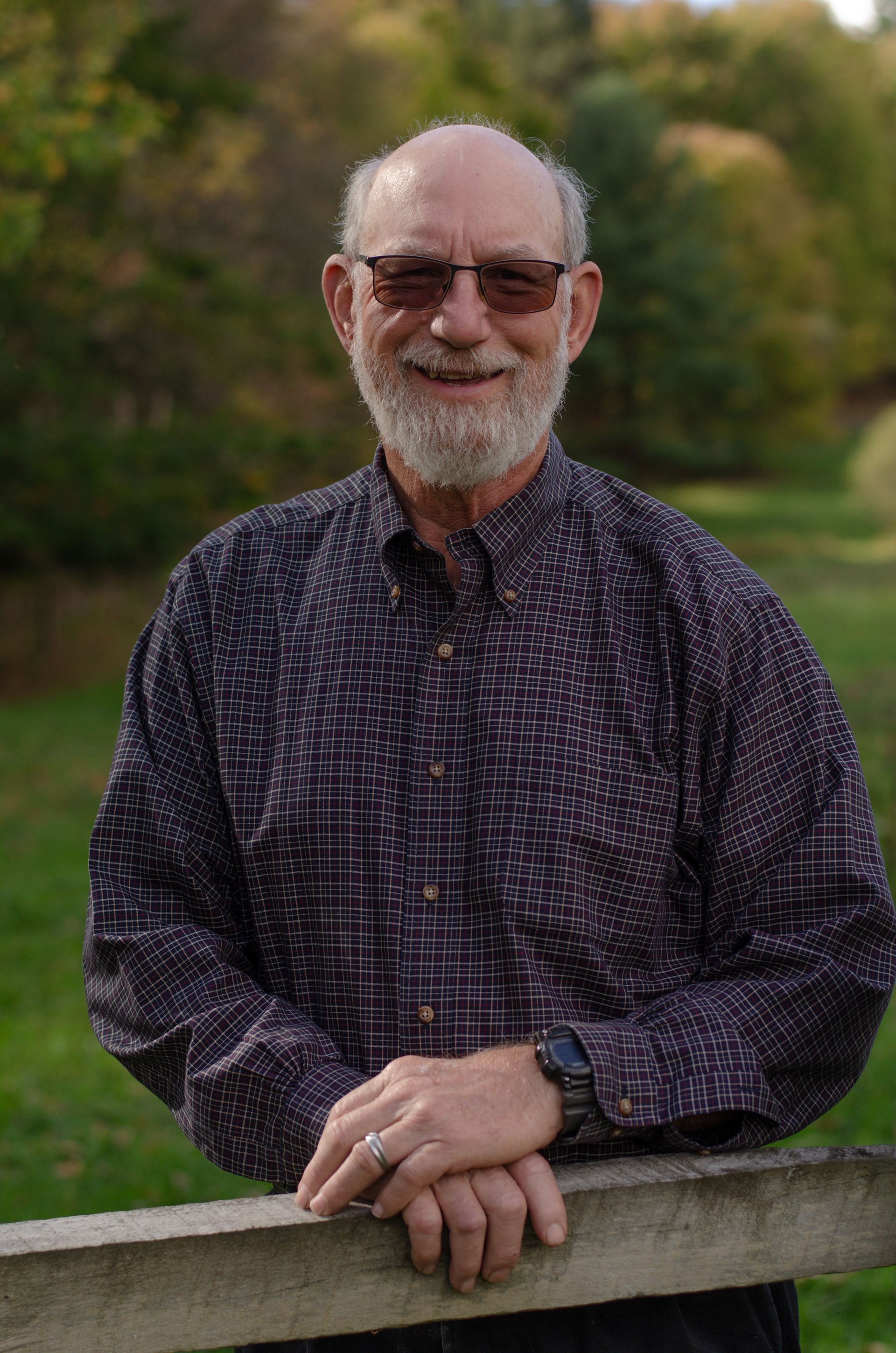 A man is paddling a yellow kayak with a black dog