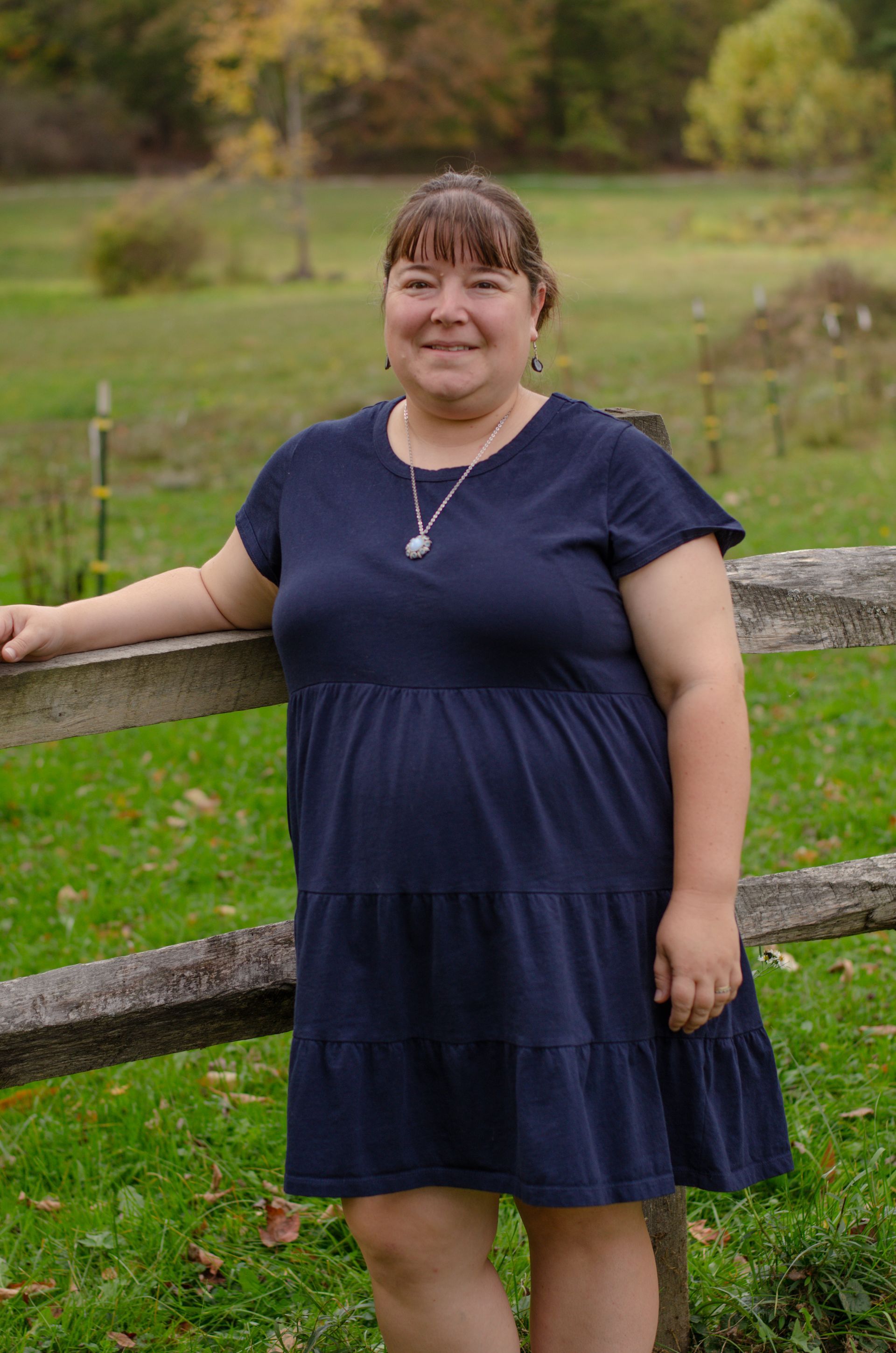 A woman with long hair and earrings is smiling for the camera.