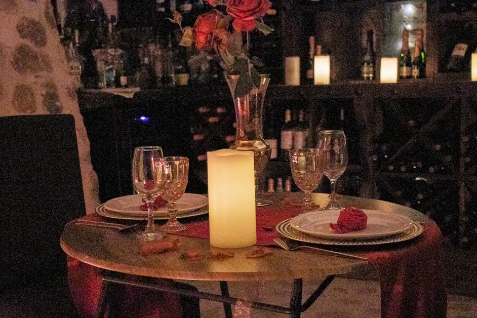 Romantic table setting with candle, roses, and wine glasses, ready for a date.