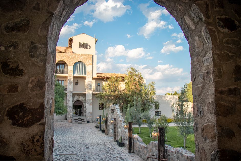 Stone archway frames a hotel building with a 