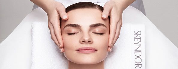 una mujer recibe un masaje facial en un spa.
