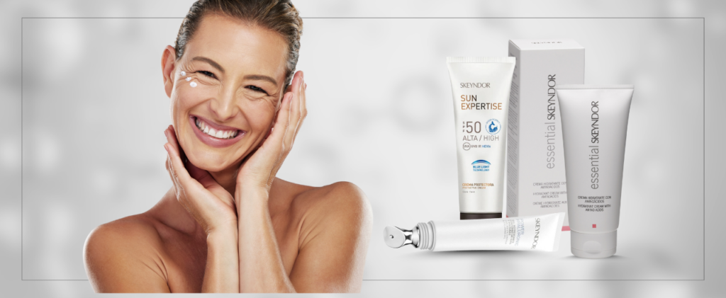 una mujer sonríe y se toca la cara junto a un tubo de Protector Solar Sun Expertise SPF50