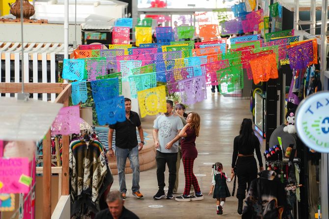 Menu on a wooden table in a colorful Mexican restaurant with paper flags and bright lights.