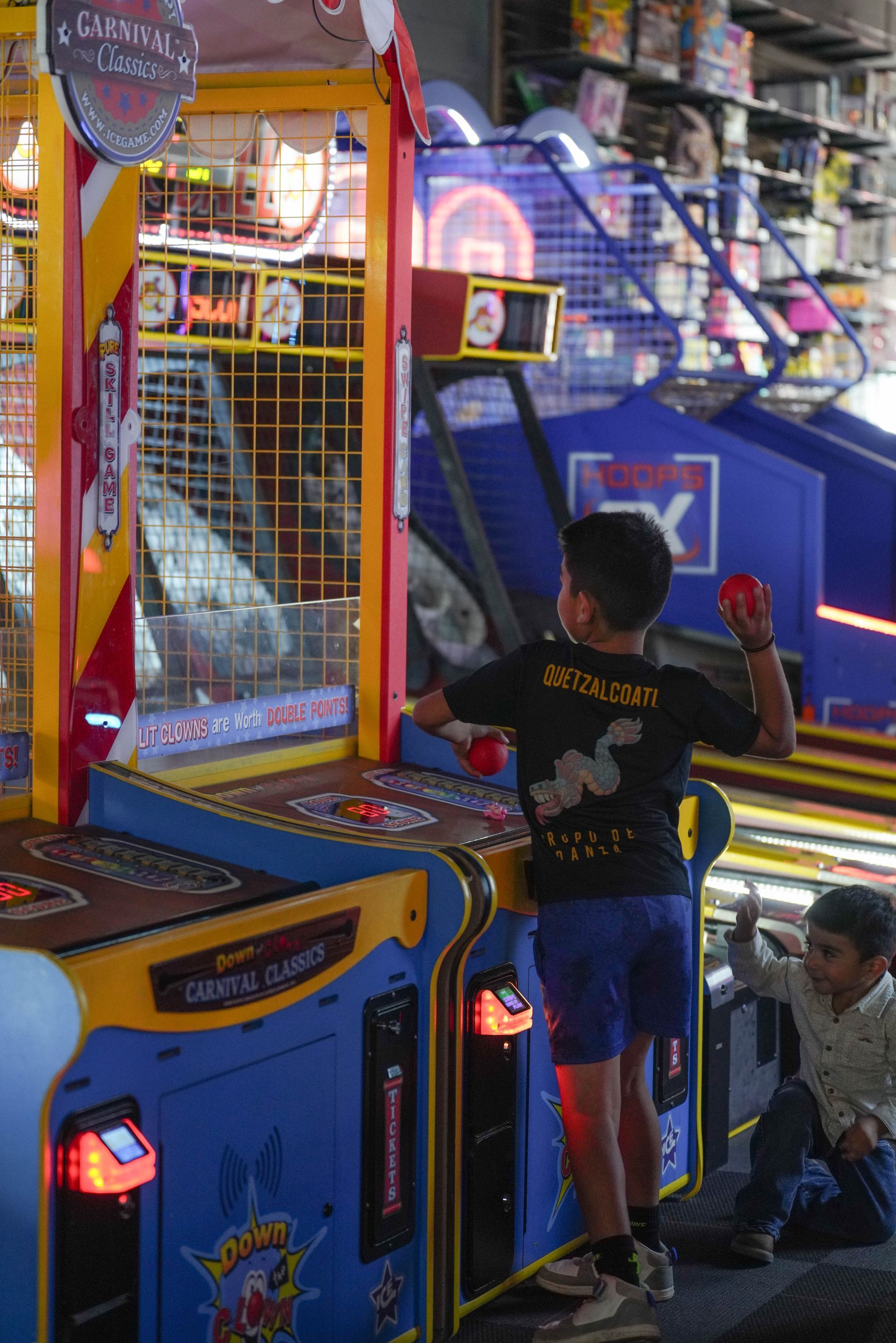 Indoor playground with a large, multi-level climbing structure, slides, and play equipment on a turf-like surface.
