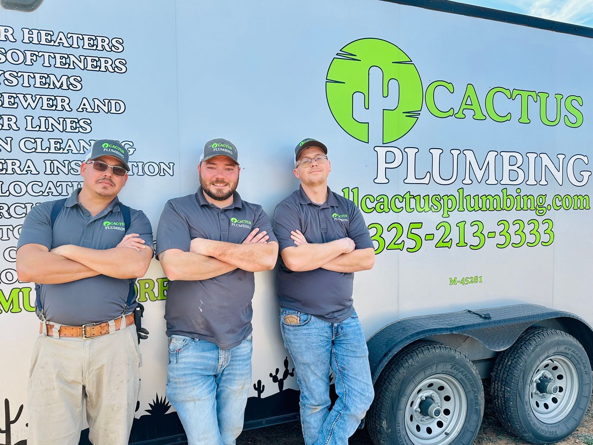 Three men in matching shirts with the Cactus Plumbing logo standing beside a trailer with the logo.