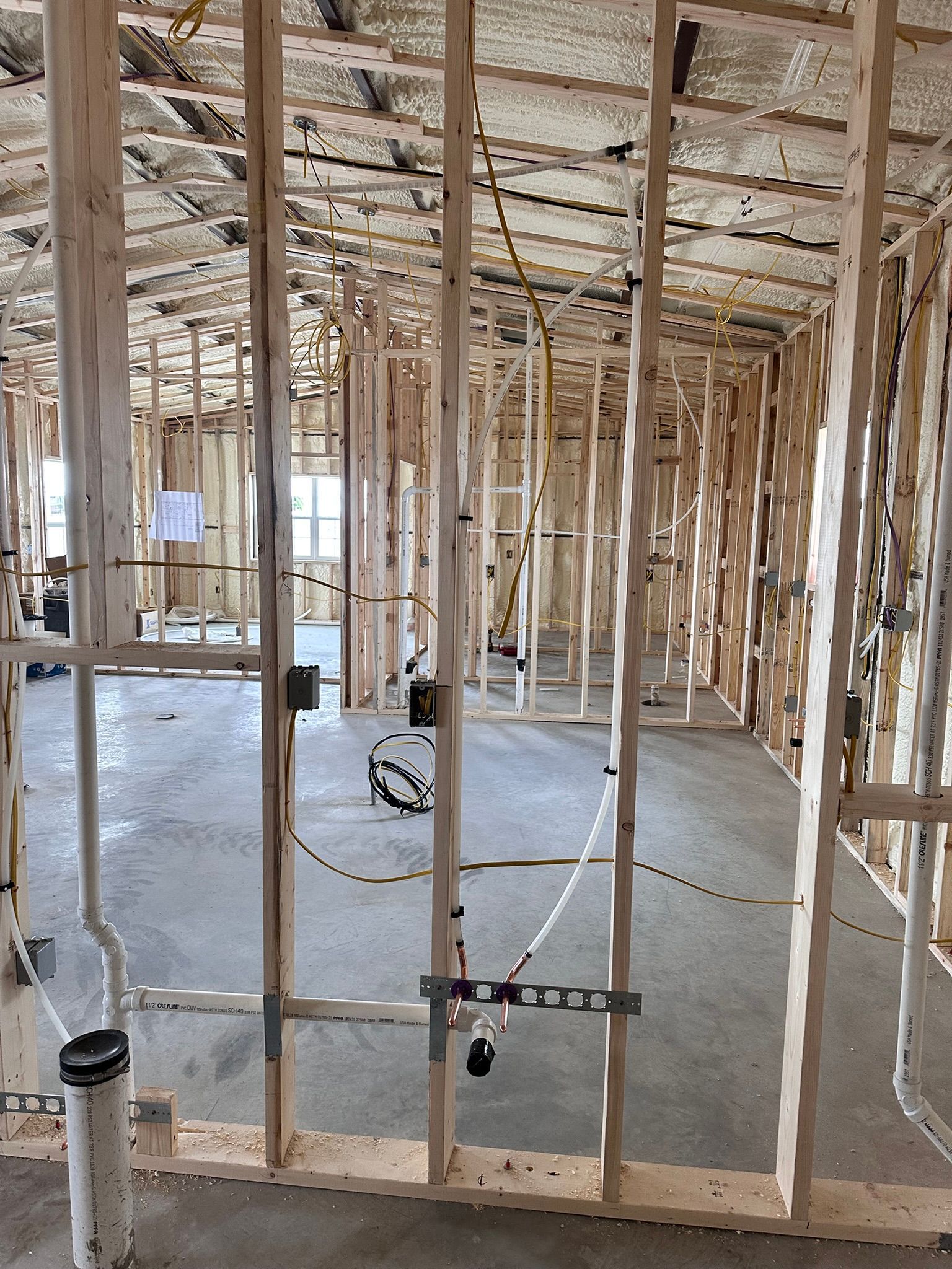 Man kneeling, repairing irrigation system in yard, surrounded by dirt and supplies.