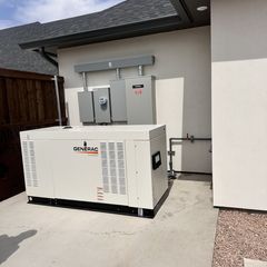 A Generac generator installed outside a house, with electrical panels above.