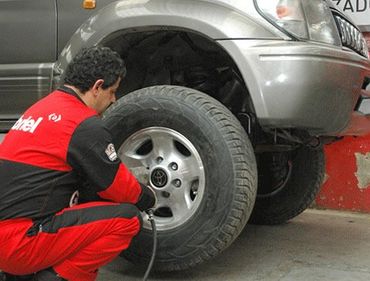 Peláez Amortiguadores y Amortiguadores hombre reparando neumático