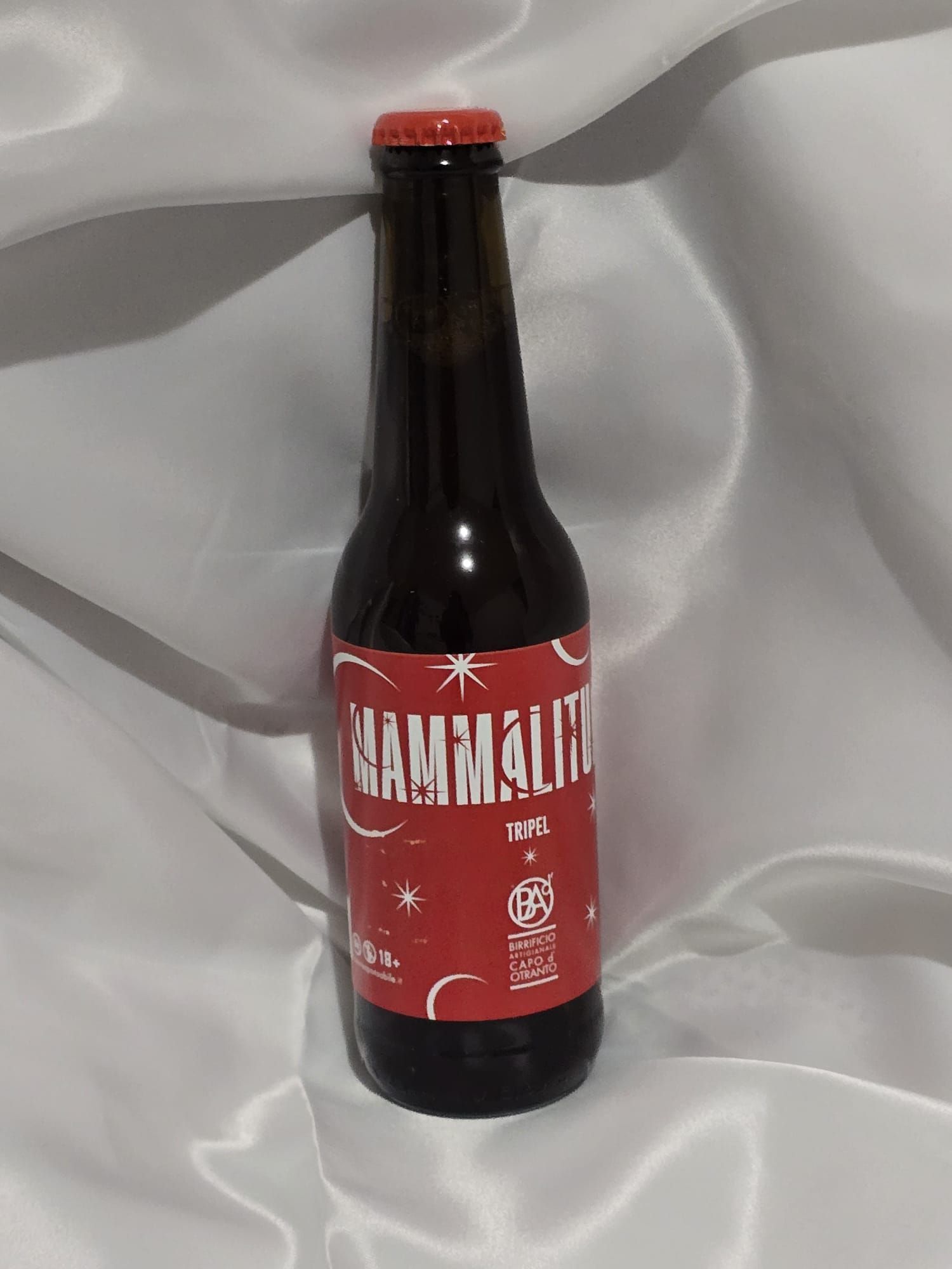 Une bouteille de gammalite repose sur un tissu blanc