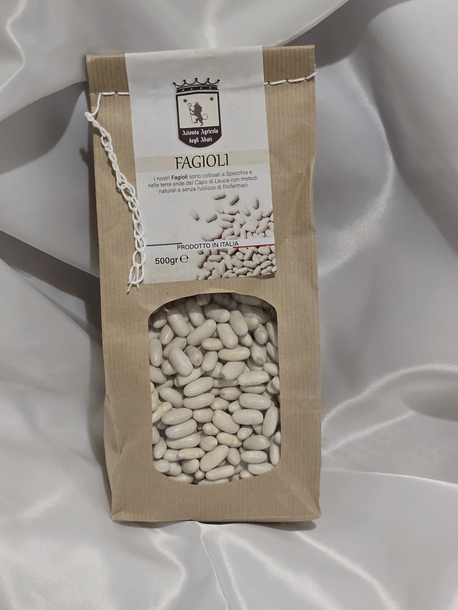 Un sac de haricots blancs est posé sur un tissu blanc