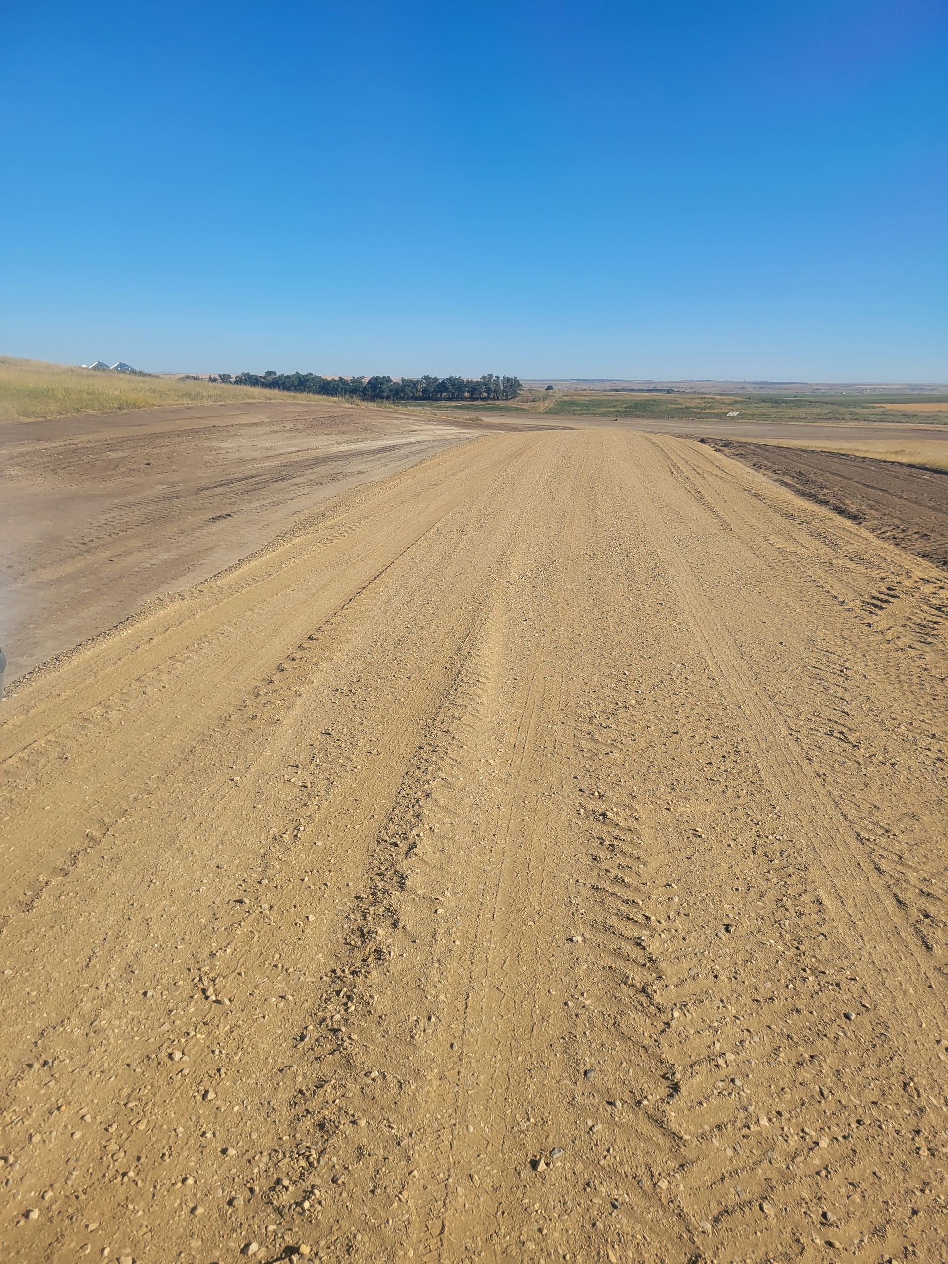 A dirt road leading to a body of water