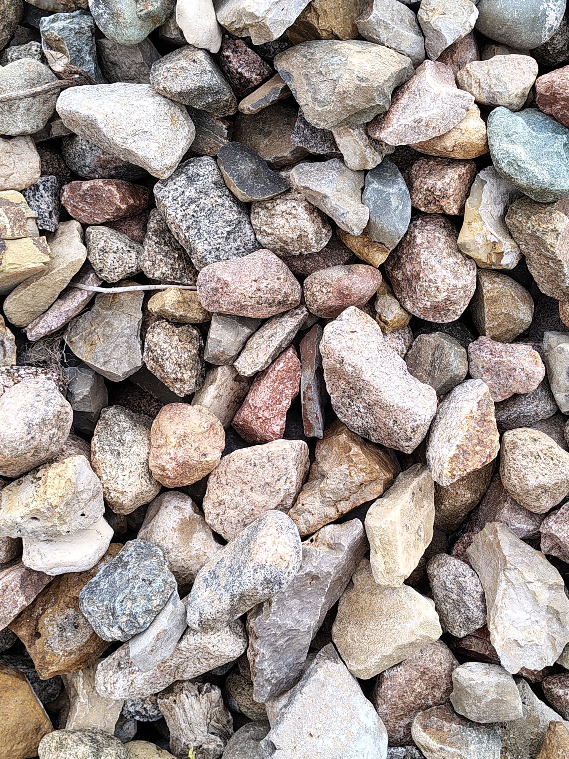 Pile of varied-color gravel rocks, including white, gray, beige, and reddish-brown.