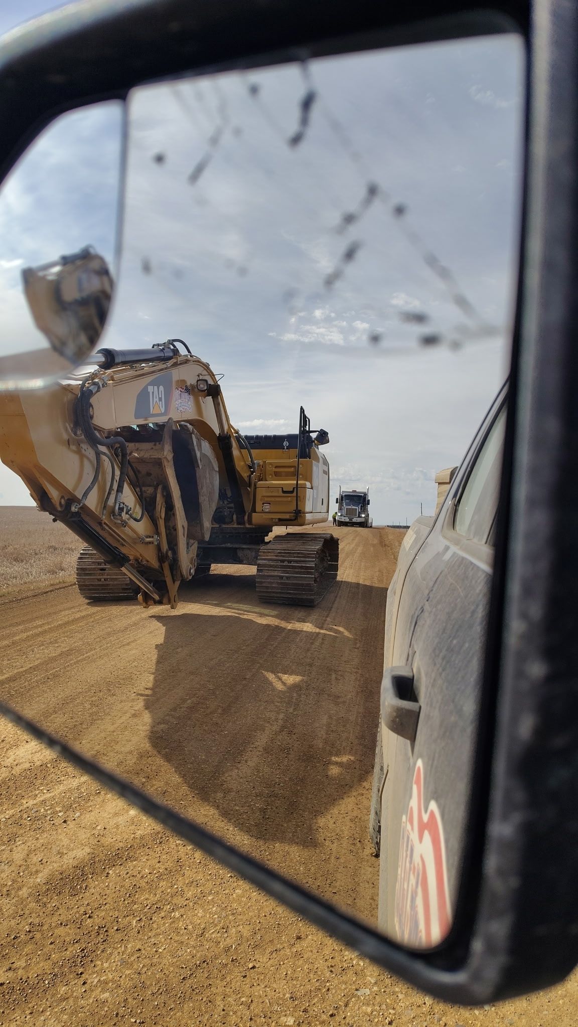 A large yellow bulldozer is parked in a grassy field.