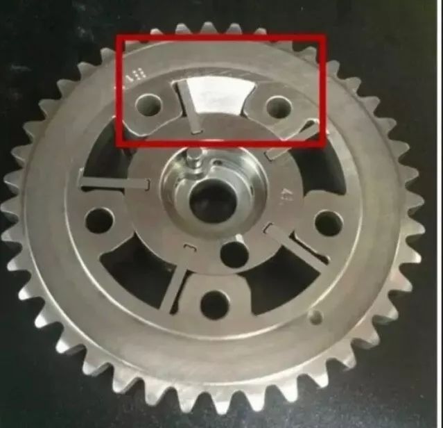 A close up of a metal gear with a red circle around it