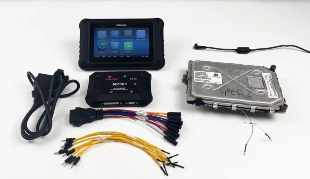 A tablet is sitting on top of a table next to a hard drive and a bunch of wires.