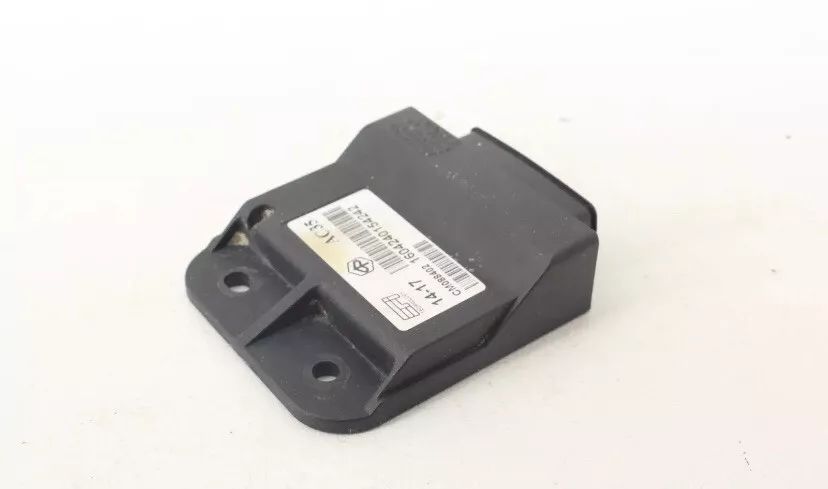 A small black electronic device is sitting on a white surface.