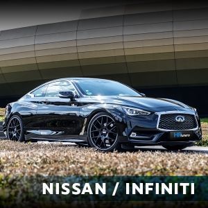 A black nissan infiniti is parked in front of a building.