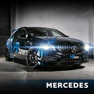 A black and blue mercedes is parked in a garage.
