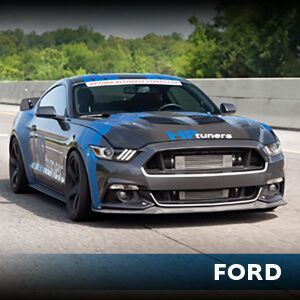 A blue and black ford mustang is driving down a highway.