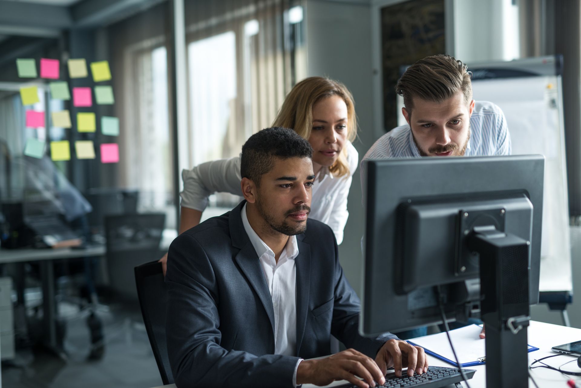A group of people are looking at a computer screen.