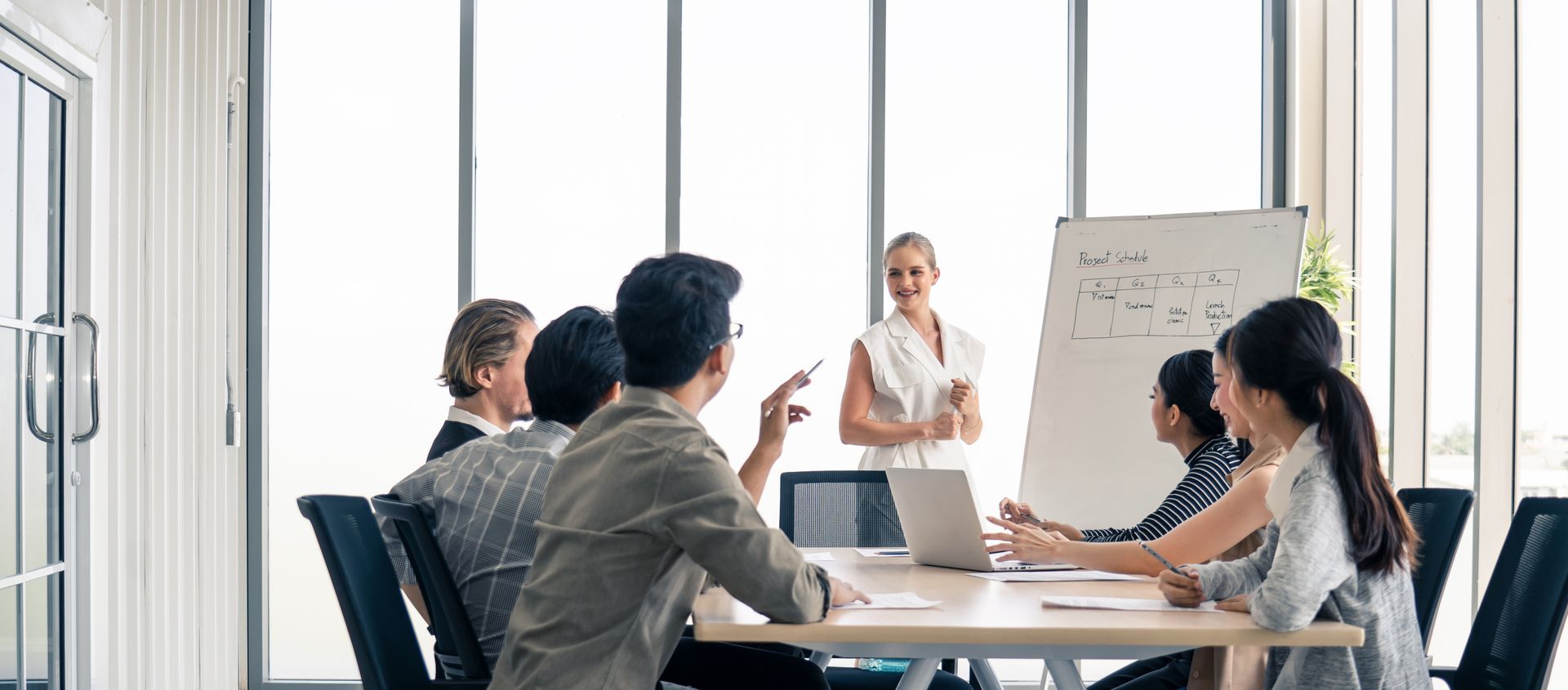 A group of people are sitting around a table in a conference room.