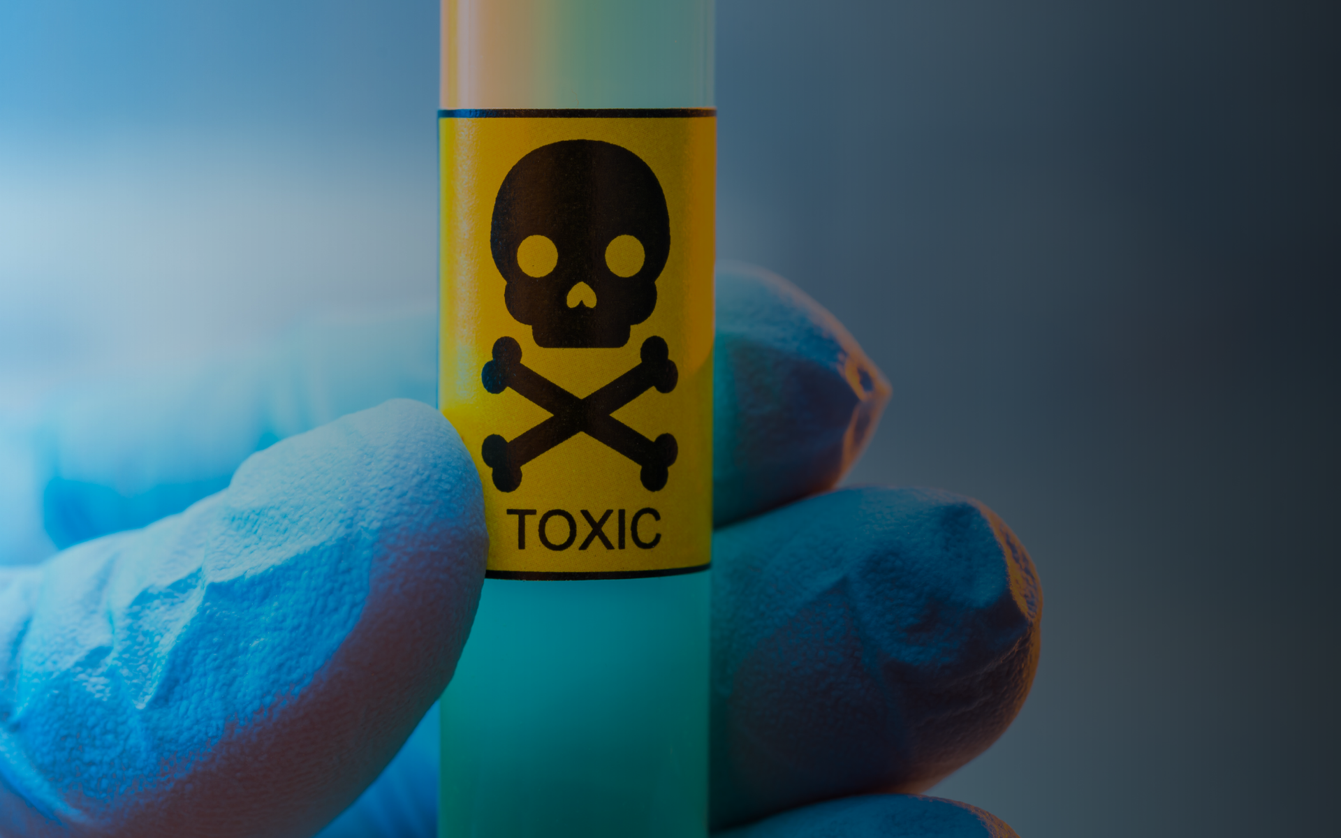 Gloved hand holding a tube of liquid that says 