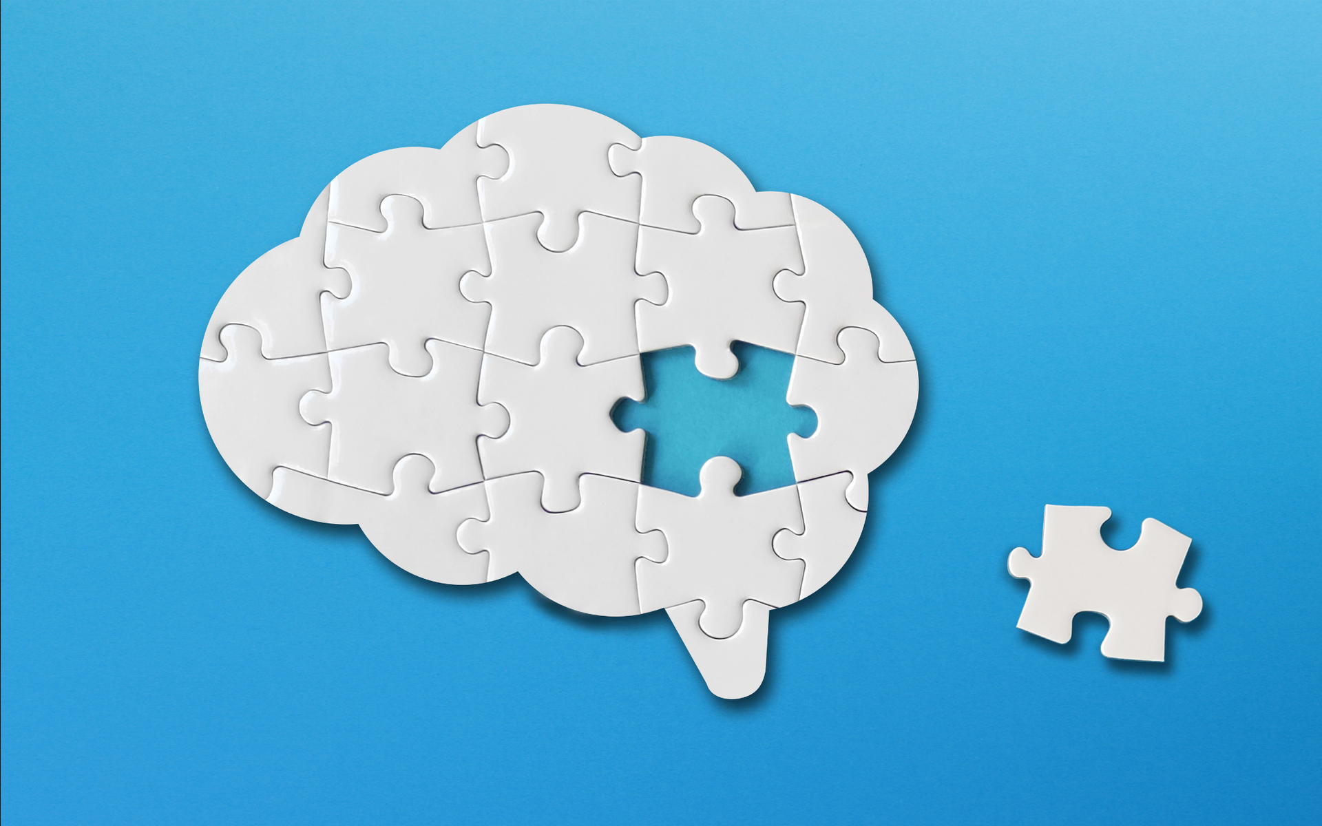 Puzzle shaped into a brain on a blue background
