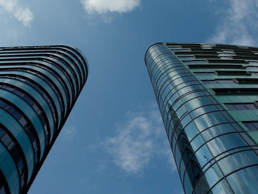 Two tall buildings with a blue sky in the background