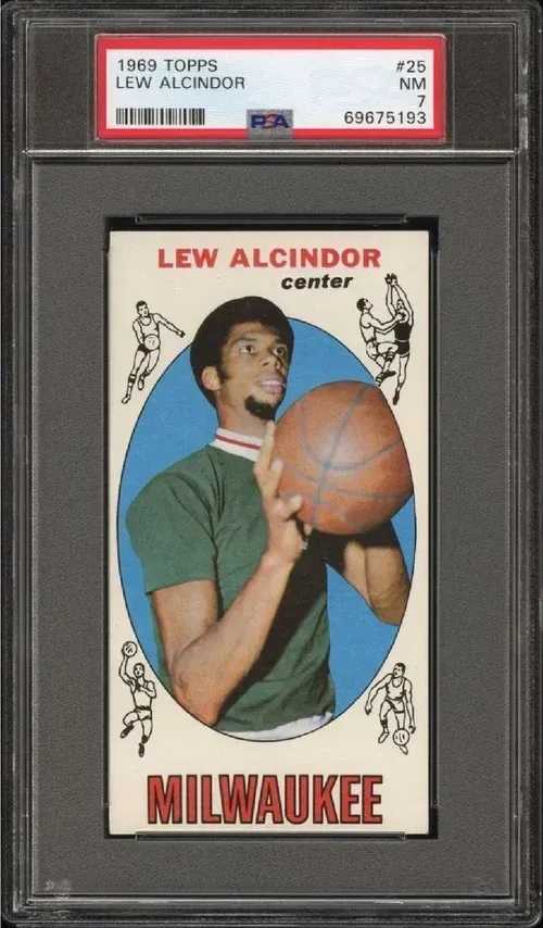 1969 Topps Lew Alcindor basketball card graded PSA 7. Center is in a green shirt holding a basketball.