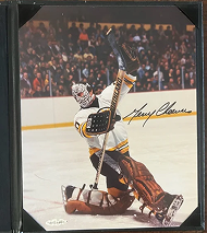 Hockey goalie Gerry Cheevers in Bruins uniform, celebrating a save, signature visible.