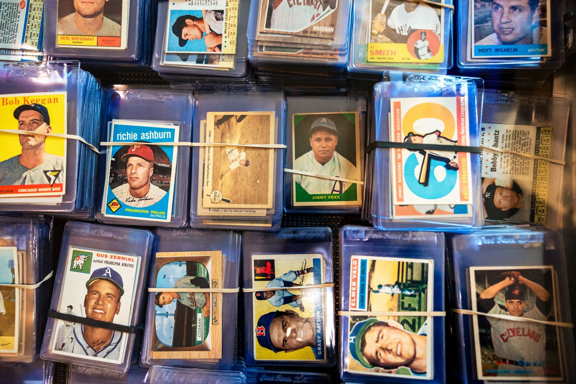 Baseball cards in protective sleeves, bundled with rubber bands.