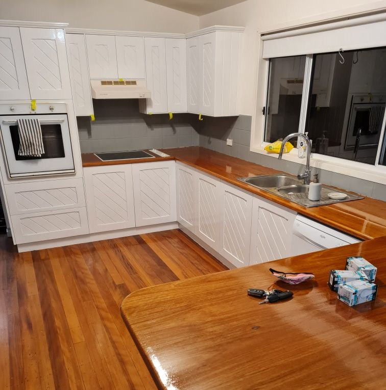 White kitchen with wooden countertops and floor — AMAC Painting & Maintenance Nowra In Nowra, NSW