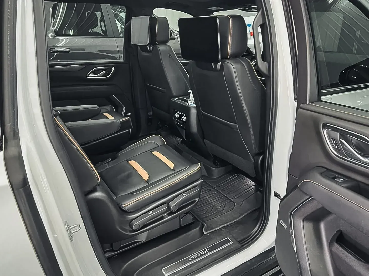 The back seat of a white suv with the door open.